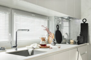 Minimalistic and modern white kitchen interior with furniture and kitchen accessories in stylish home decor. Windows. Details. Template.